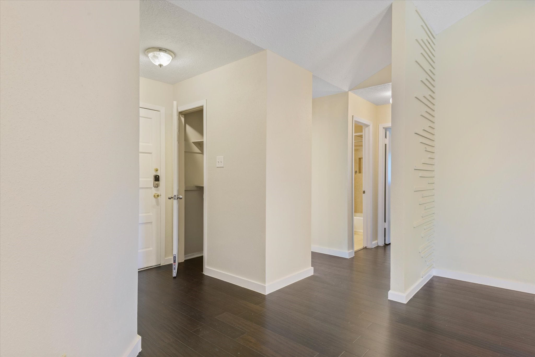 2507 Kings Chapel Road Friendswood, TX 77546 - Photo 4 of 28 Step inside to a light, neutral entry with durable dark stained bamboo flooring and clean sightlines into the main living areas. A nearby closet offers convenient storage, while the hallway layout creates separation between the living space and secondary rooms.