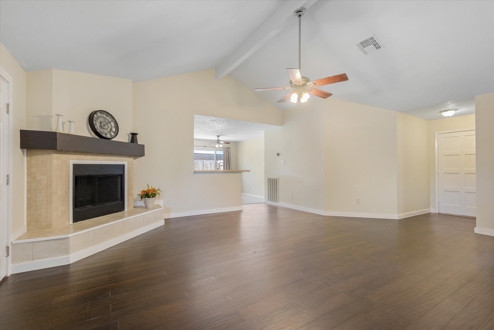 2507 Kings Chapel Road Friendswood, TX 77546 - Photo 5 of 28 Continue into a spacious family room with rich bamboo flooring, vaulted ceilings, and an open layout that connects seamlessly to the kitchen. The updated fireplace anchors the room, while the elevated ceiling adds volume and an airy feel.