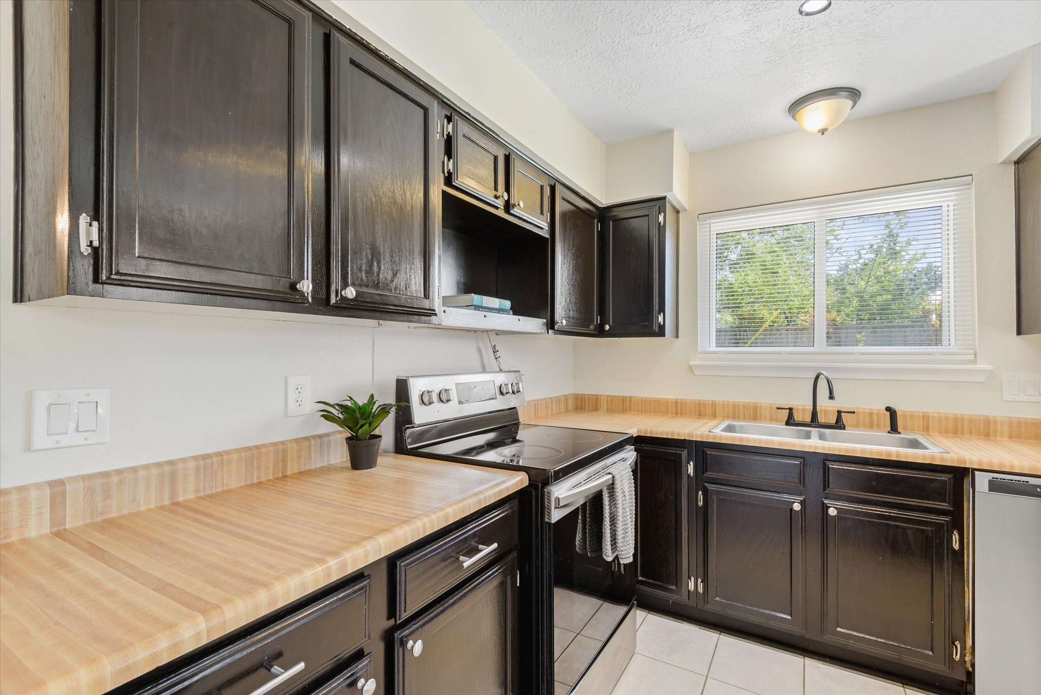 2507 Kings Chapel Road Friendswood, TX 77546 - Photo 8 of 28 Here, you can see the abundance of upper and lower cabinetry paired with durable counters and a clean tile backsplash. The layout provides plenty of prep space, with everything positioned within easy reach.