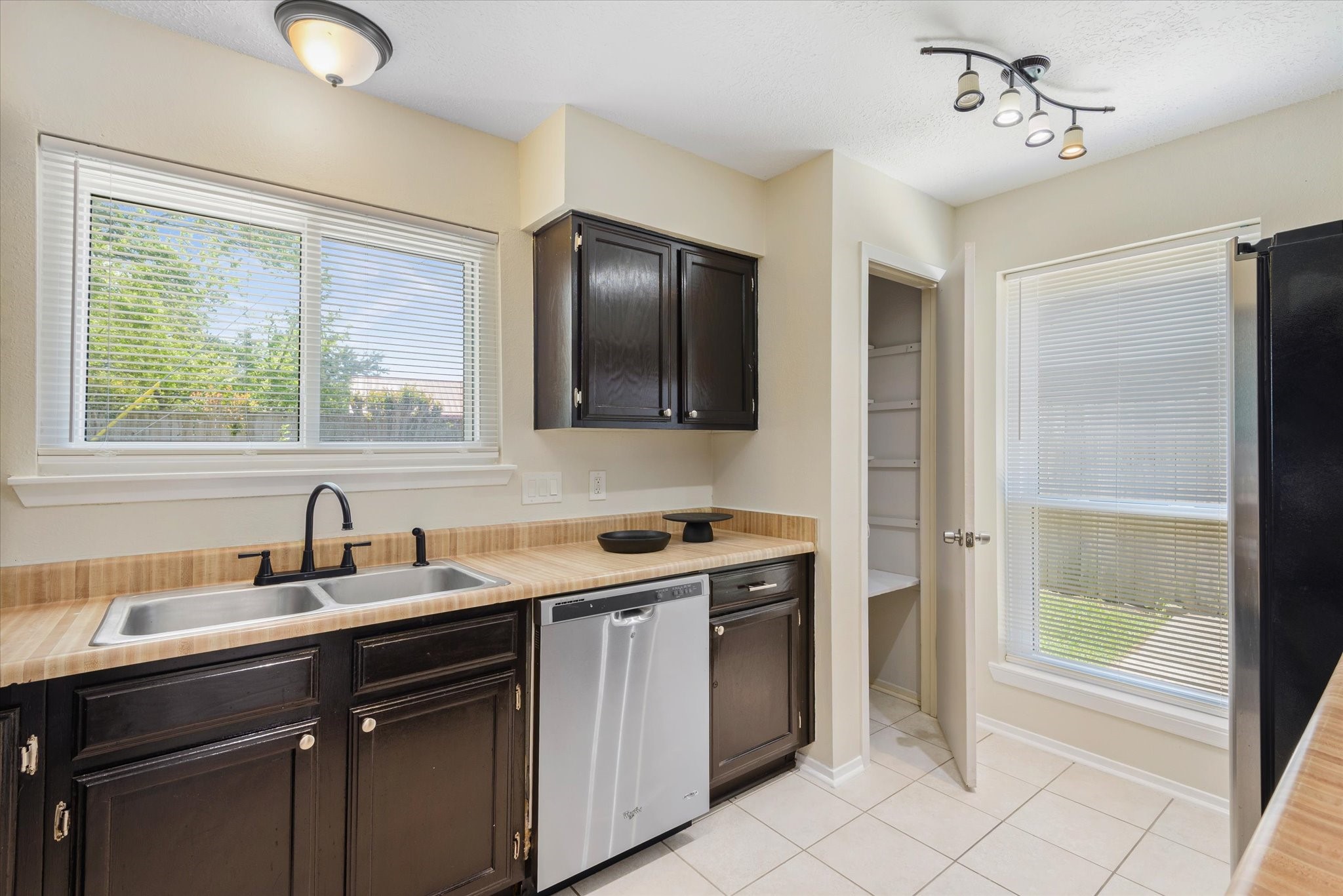 2507 Kings Chapel Road Friendswood, TX 77546 - Photo 9 of 28 Natural light pours in through the window above the sink, brightening the workspace. This side of the kitchen also offers additional storage and a nearby pantry, giving you plenty of room to stay organized.