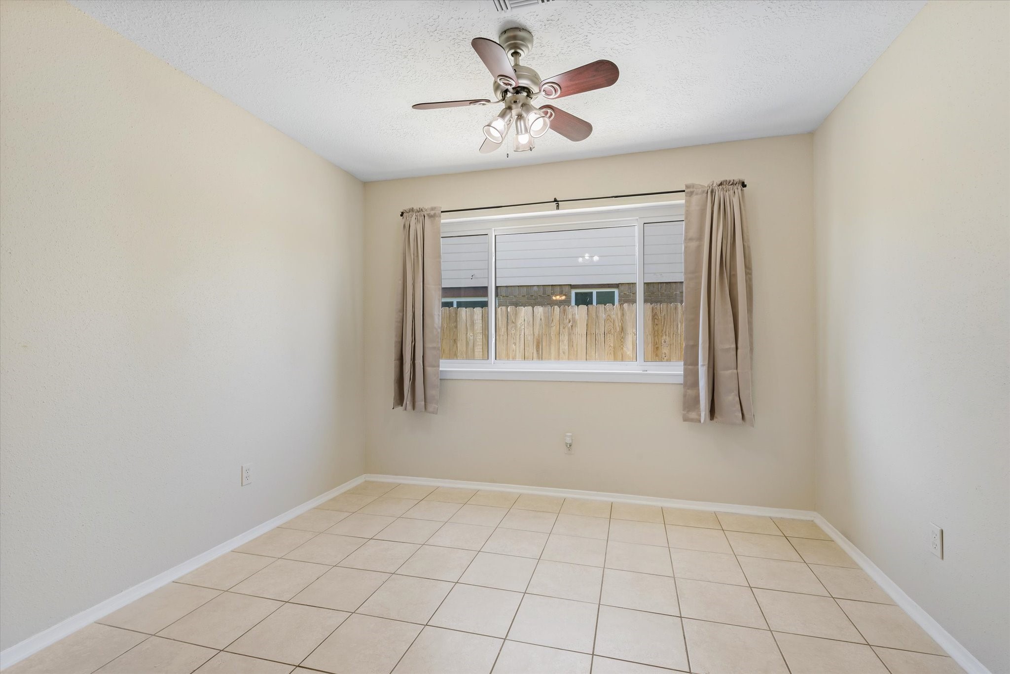 2507 Kings Chapel Road Friendswood, TX 77546 - Photo 10 of 28 Situated between the kitchen and family room, this sunlit dining space offers a lighted ceiling fan, durable tile floors, neutral paint, and a side facing window shaded by draperies.
