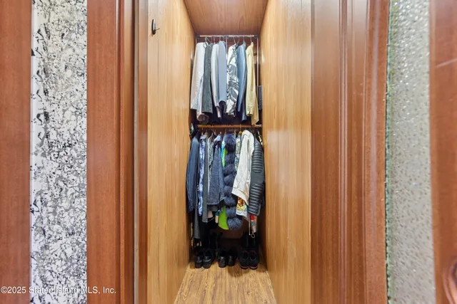 a view of a hallway with wooden floor and a entryway