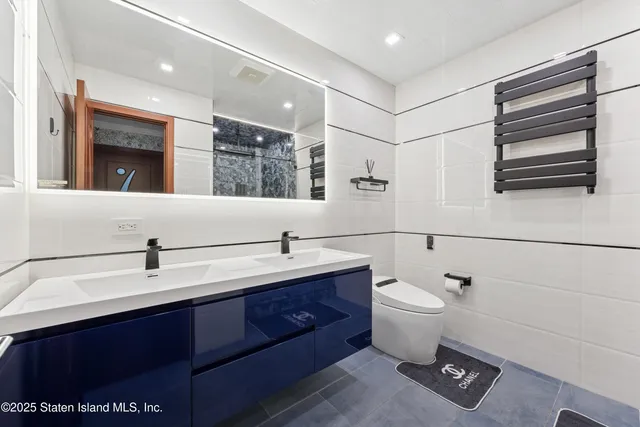 a bathroom with a double vanity sink toilet and mirror