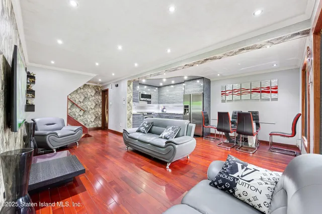a living room with furniture kitchen view and a large window