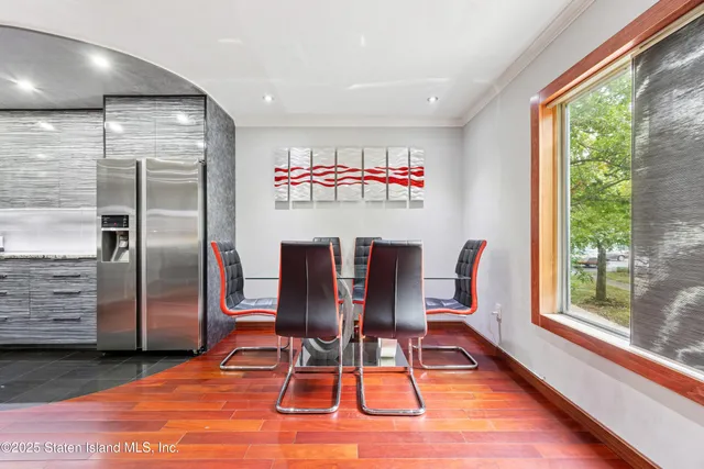 a view of a dining room with furniture a rug and wooden floor