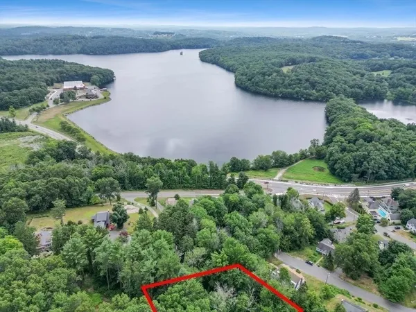 an aerial view of a houses with a yard and lake view