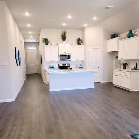 a view of kitchen with sink and refrigerator
