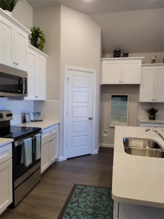 a kitchen with granite countertop a sink a stove and cabinets