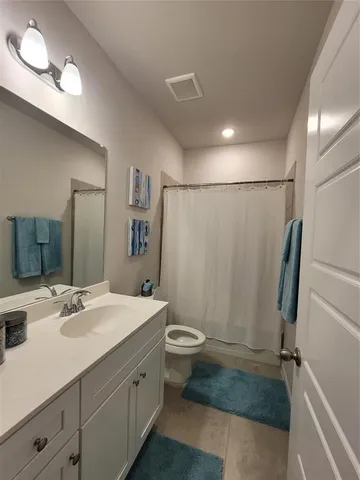 a bathroom with a sink a toilet a mirror and shower