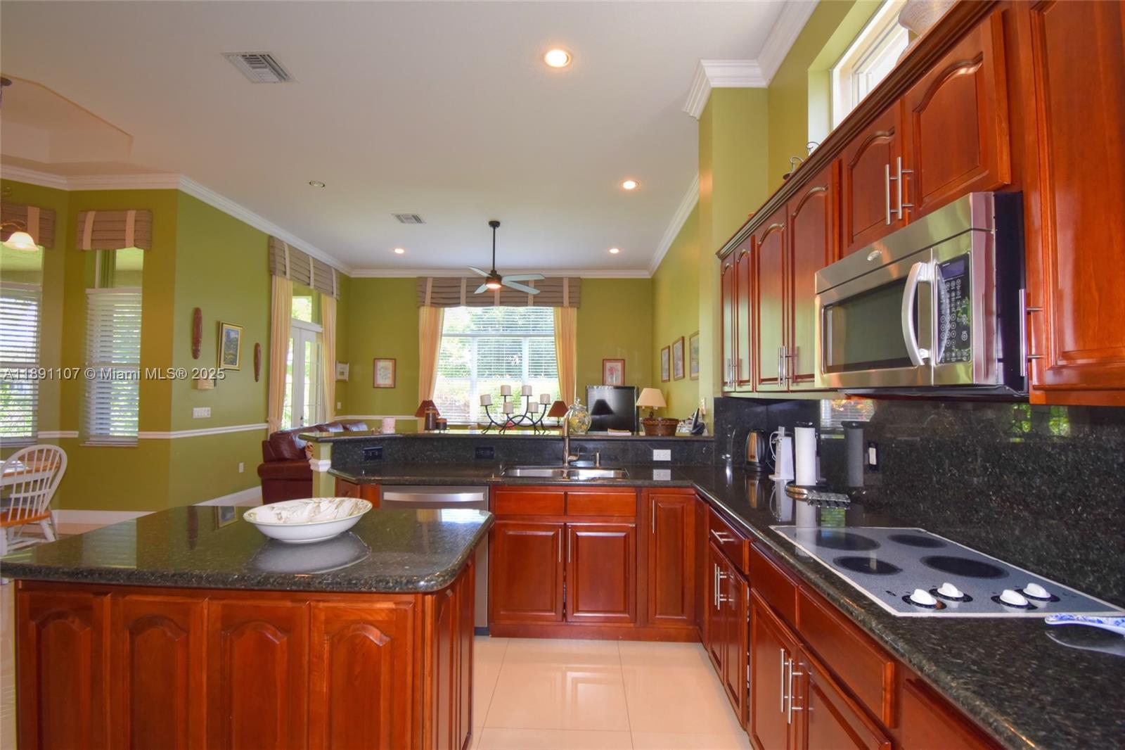 4240 Southwest 131st Avenue Davie, FL 33330 - Photo 12 of 47 a kitchen with kitchen island granite countertop a sink stove and cabinets