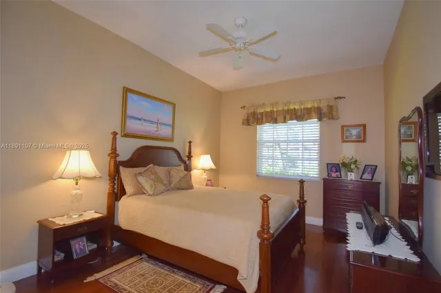 a bedroom with a bed a flat screen tv and a window