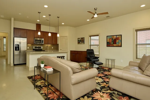 a living room with furniture and kitchen view