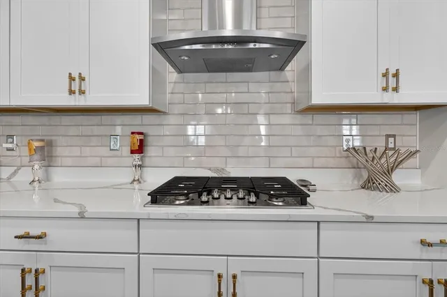 a room with stainless steel appliances kitchen island granite countertop a sink dishwasher a dining table and chairs with wooden floor