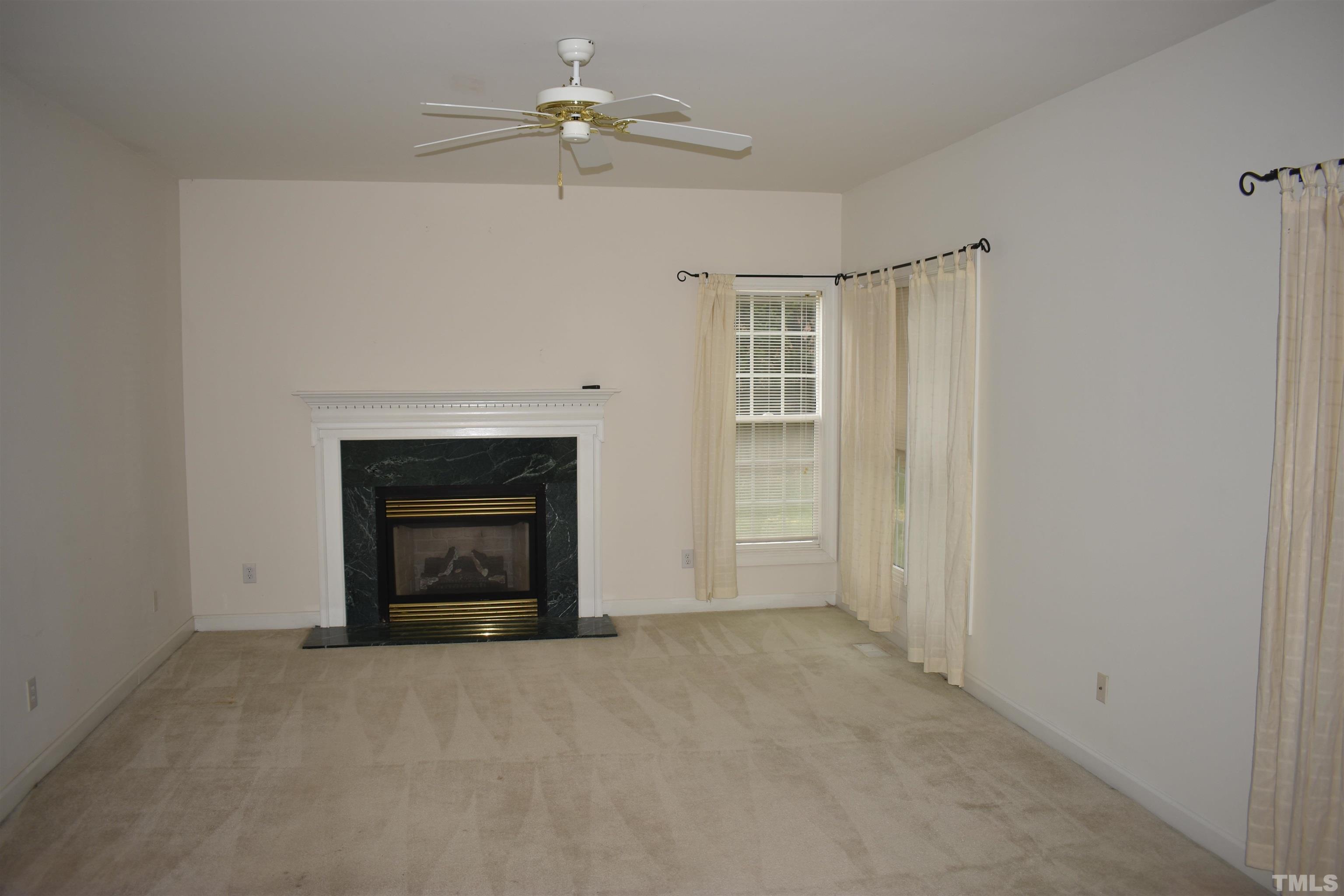 1504 Wood Spring Court Raleigh, NC 27614 - Photo 6 of 17 an empty room with a fireplace and fan