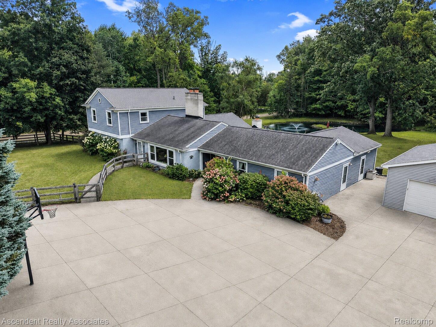 6157 Blue Beech Court Rochester, MI 48306 - Photo 1 of 30 Front of home primarily facing north and very large circle driveway. 2.5 car garage to right side of photo