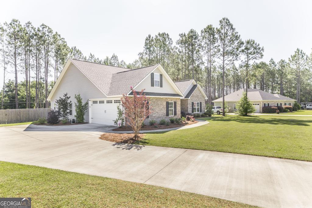 609 Live Oak Way Dublin, GA 31021 - Photo 6 of 37 a front view of house with yard and trees in the background