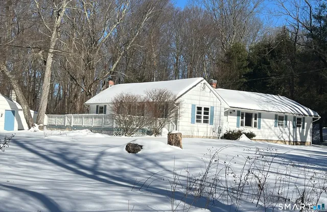 a view of a house with a yard covered in snow