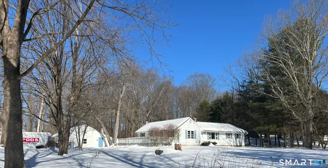 a front view of a house with a yard and trees