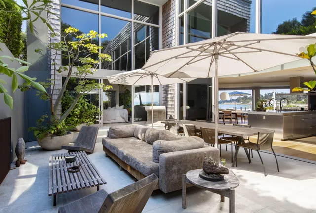 a view of a patio with couches table and chairs and potted plants