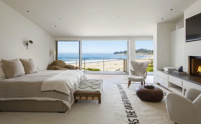 a bedroom with a bed a couch and a flat screen tv