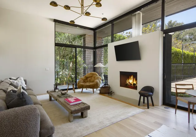 a living room with furniture a flat screen tv and a fireplace