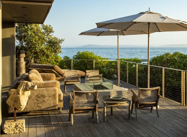 a view of deck with table and chairs under an umbrella