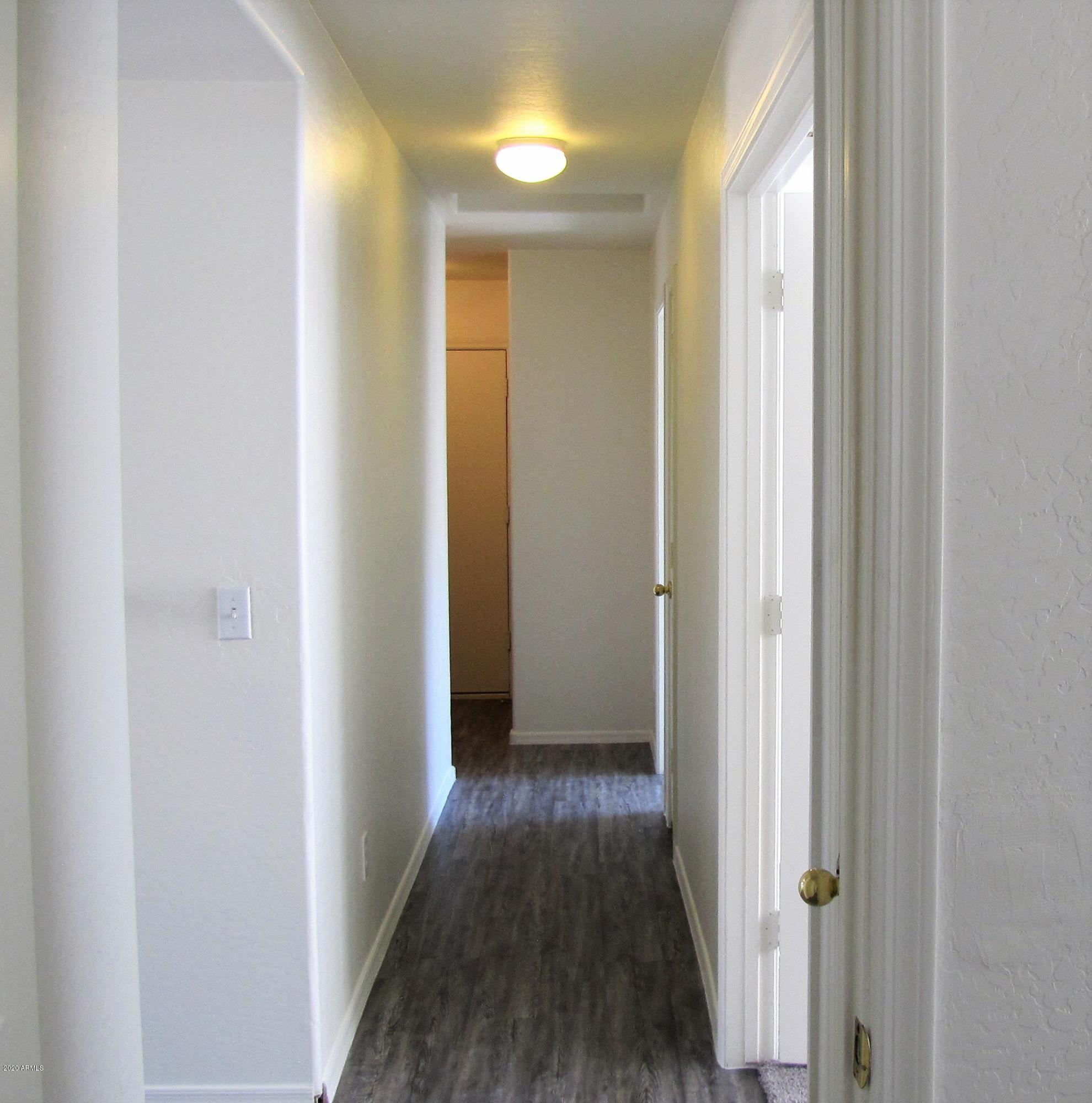 16086 West Calavar Road Surprise, AZ 85379 - Photo 13 of 28 a view of a hallway with wooden floor
