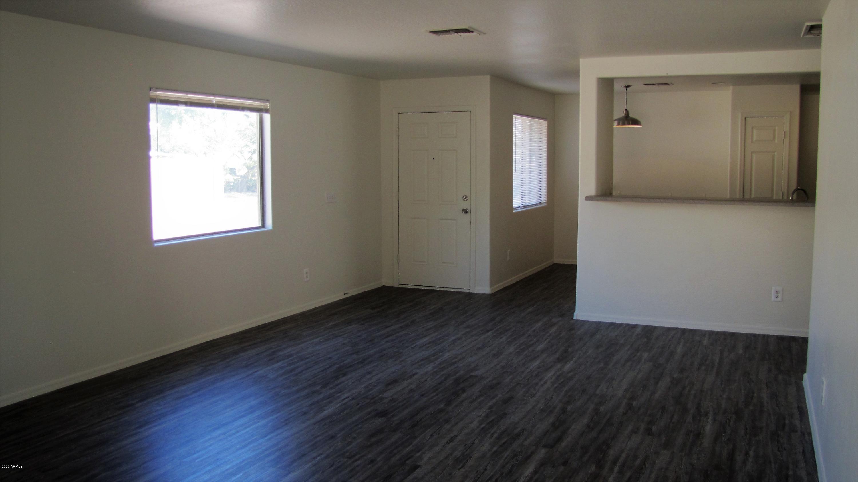 16086 West Calavar Road Surprise, AZ 85379 - Photo 23 of 28 an empty room with wooden floor and a window