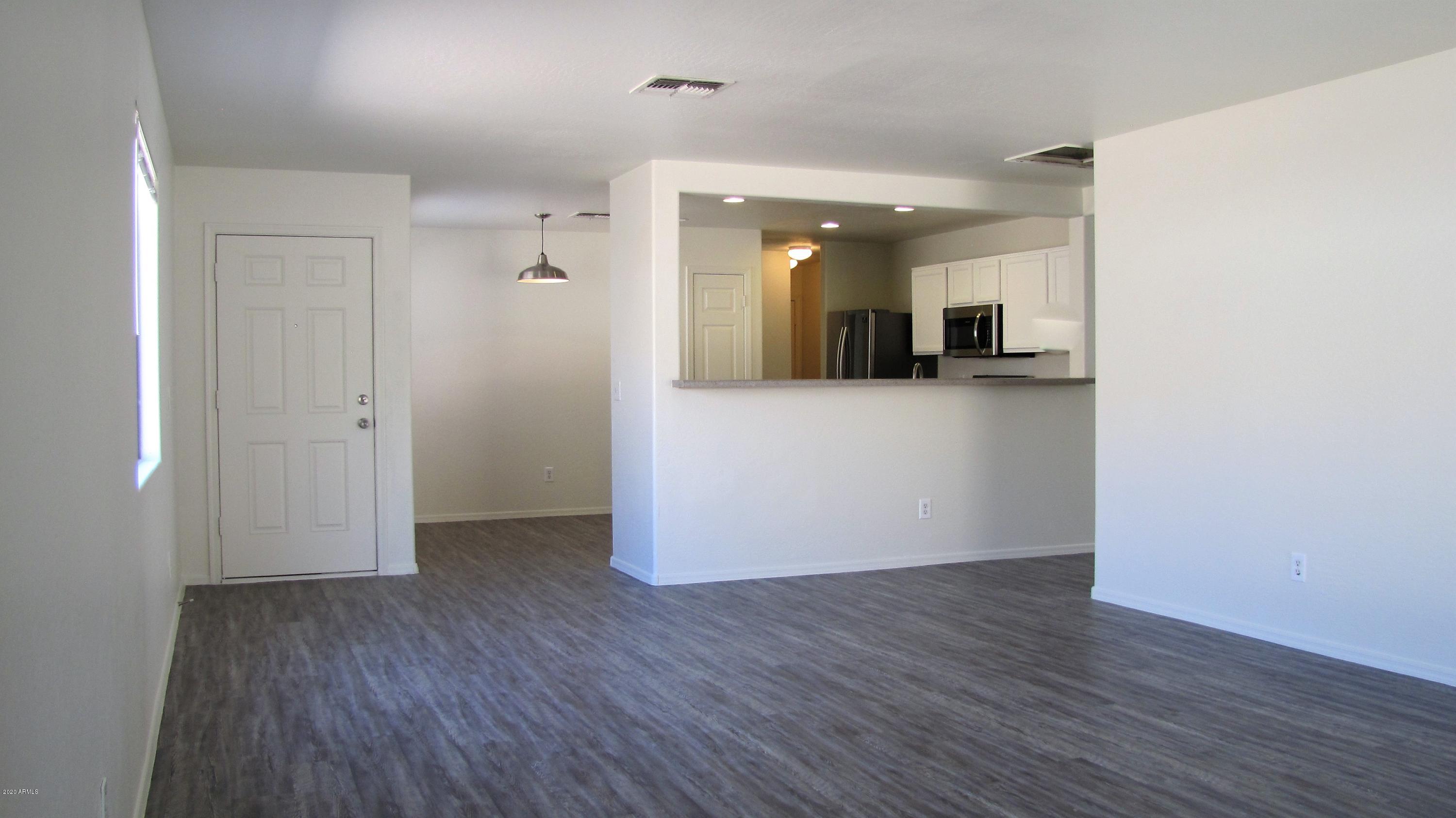 16086 West Calavar Road Surprise, AZ 85379 - Photo 4 of 28 wooden floor in an empty room with a window