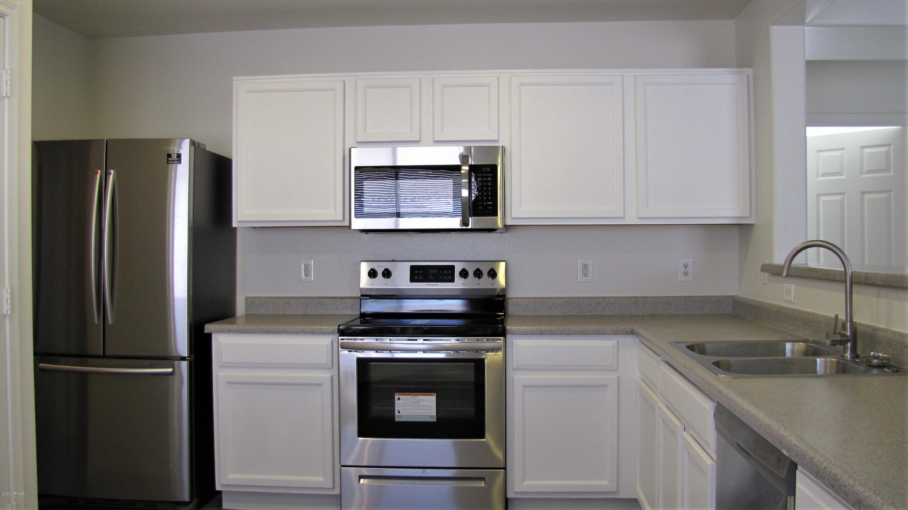 16086 West Calavar Road Surprise, AZ 85379 - Photo 6 of 28 a kitchen with a refrigerator stove and sink