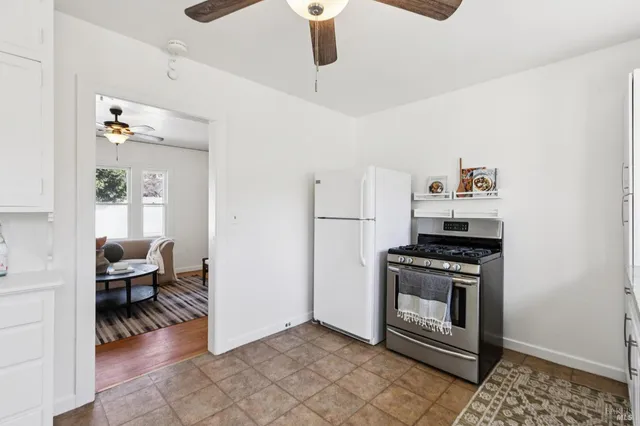 a kitchen with stainless steel appliances granite countertop a stove and a refrigerator with white cabinets