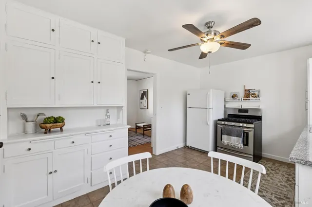 a kitchen with white cabinets and stainless steel appliances
