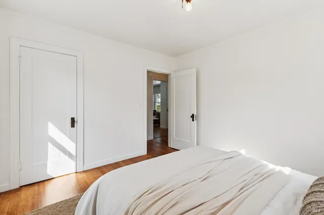 a bedroom with a bed and wooden floor