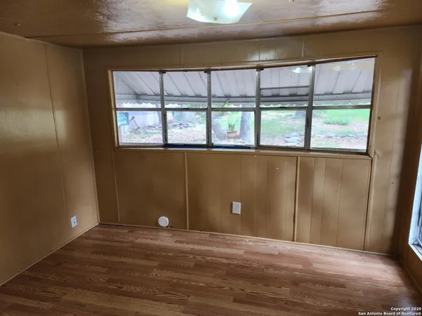 a view of a livingroom with a window and wooden floor