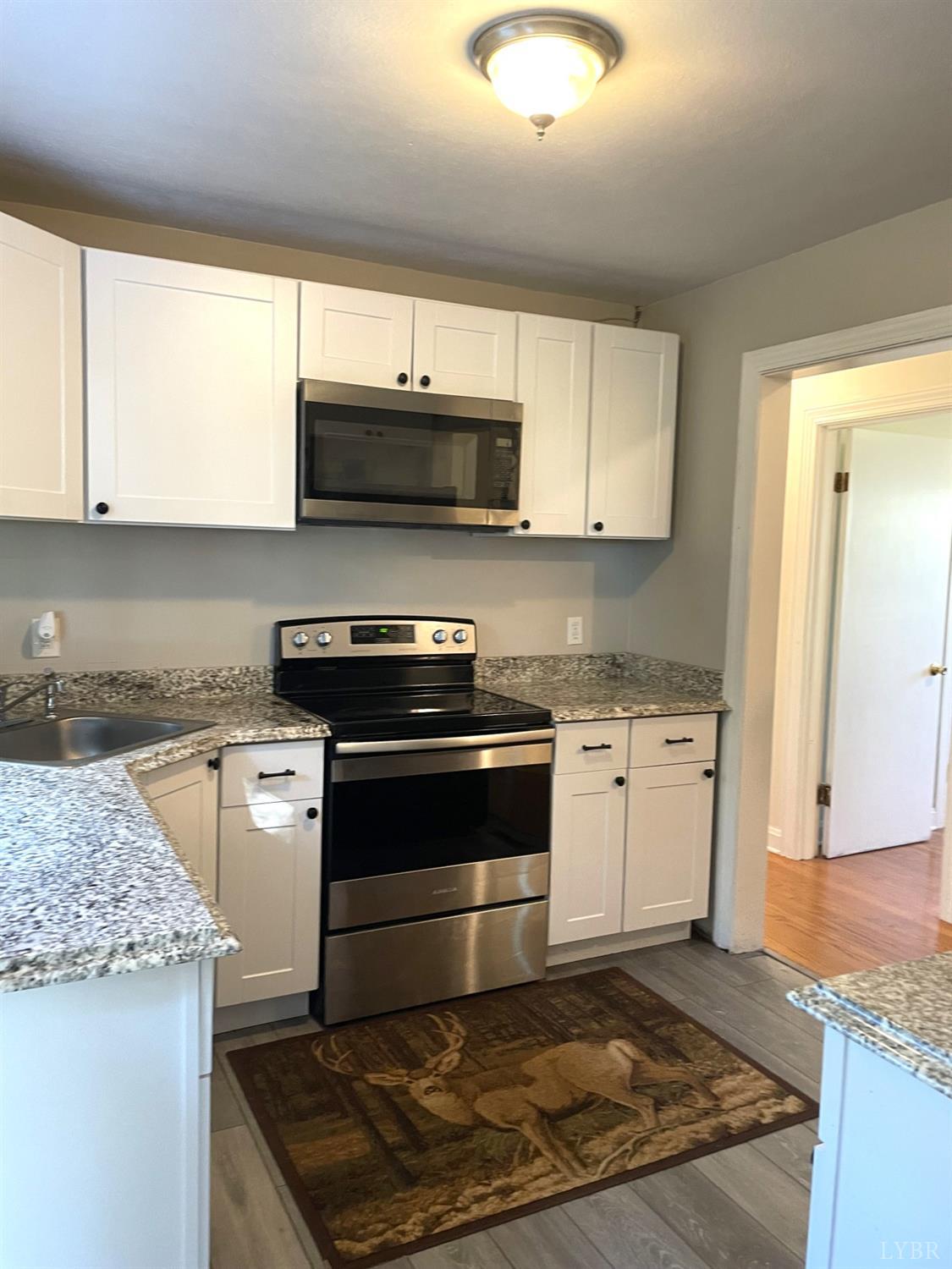 6181 Renan Road Hurt, VA 24563 - Photo 19 of 35 a kitchen with stainless steel appliances granite countertop a stove a sink and a microwave