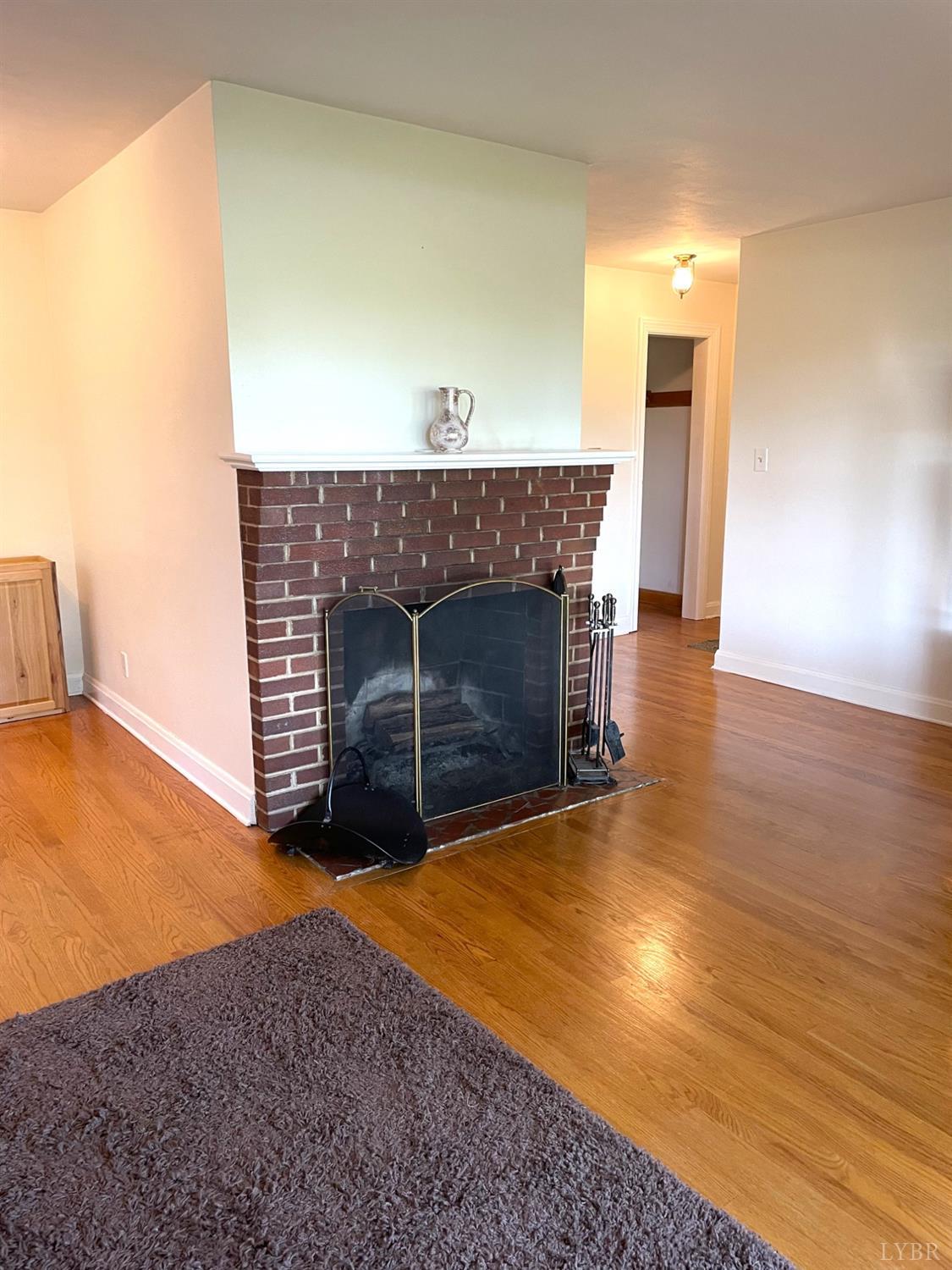 6181 Renan Road Hurt, VA 24563 - Photo 5 of 35 a view of empty room with wooden floor and fireplace