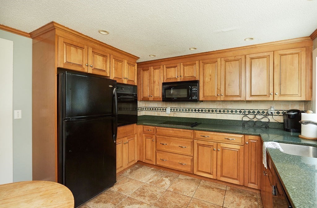 738 Sandwich Road Bourne, MA 02532 - Photo 12 of 25 a kitchen with stainless steel appliances granite countertop a refrigerator and a stove top oven