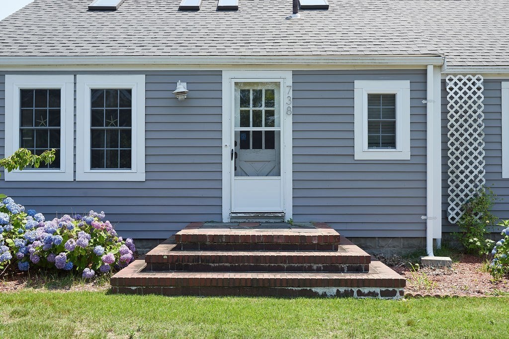 738 Sandwich Road Bourne, MA 02532 - Photo 5 of 25 a front view of a house with a garden