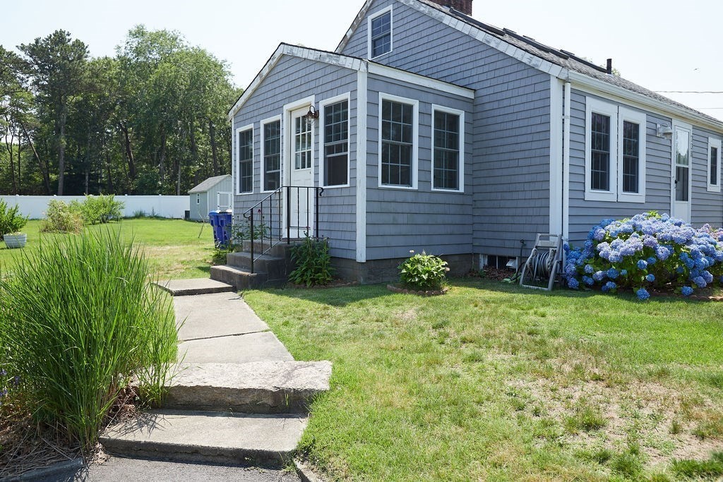 738 Sandwich Road Bourne, MA 02532 - Photo 6 of 25 a front view of a house with a garden