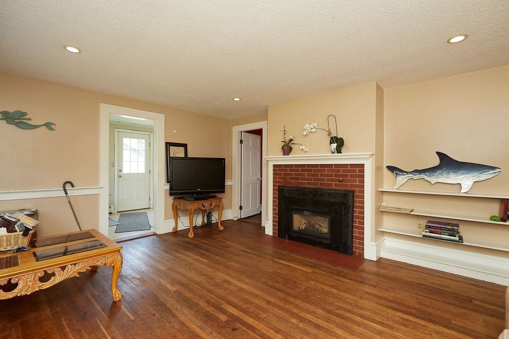 738 Sandwich Road Bourne, MA 02532 - Photo 10 of 25 a living room with furniture flat screen tv and a fireplace