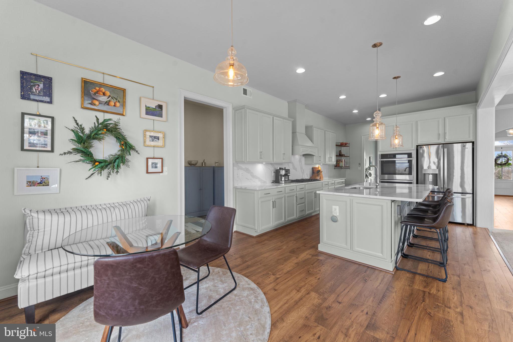 16756 Misty Ridge Lane Purcellville, VA 20132 - Photo 35 of 92 a kitchen with a sink dishwasher a dining table and chairs with wooden floor