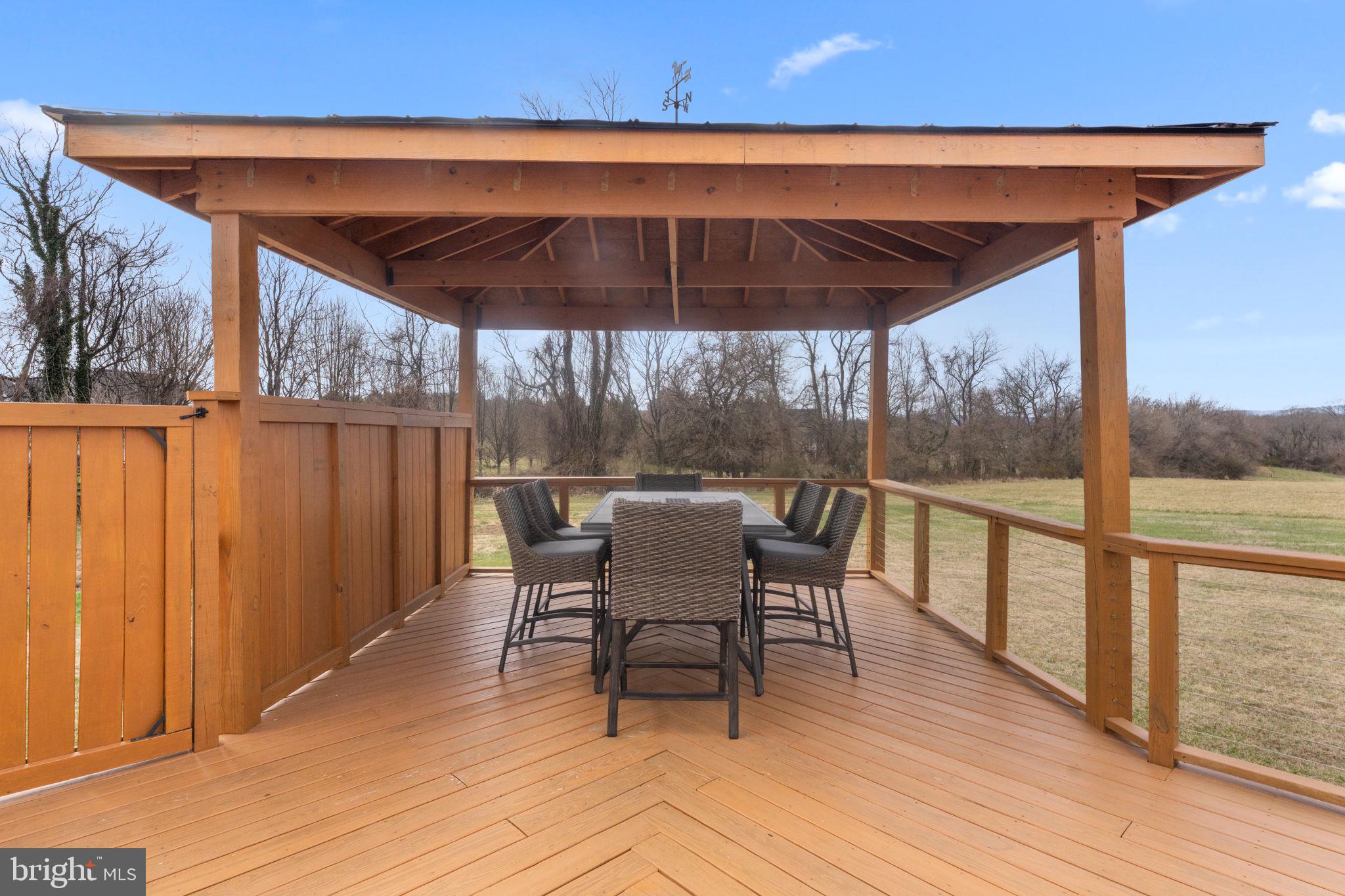 16756 Misty Ridge Lane Purcellville, VA 20132 - Photo 75 of 92 a patio with wooden floor a yard tables and chairs