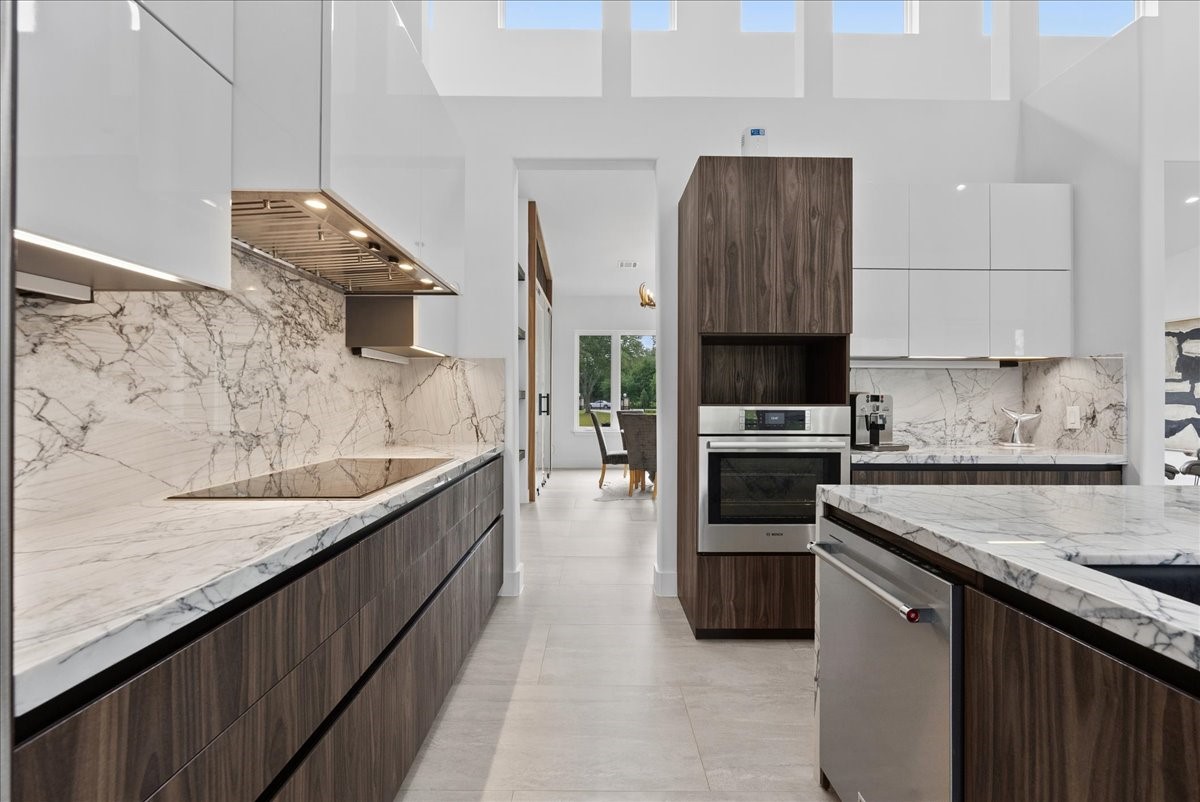7627 Scott Avenue Manvel, TX 77578 - Photo 19 of 50 This space combines high-performance utility with the home's signature modern aesthetic. All cabinets are black teak finish with wood grain touch. Thermador INDUCTION cooktop.