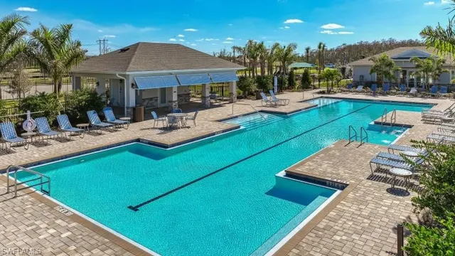 a view of a swimming pool with lounge chairs in patio