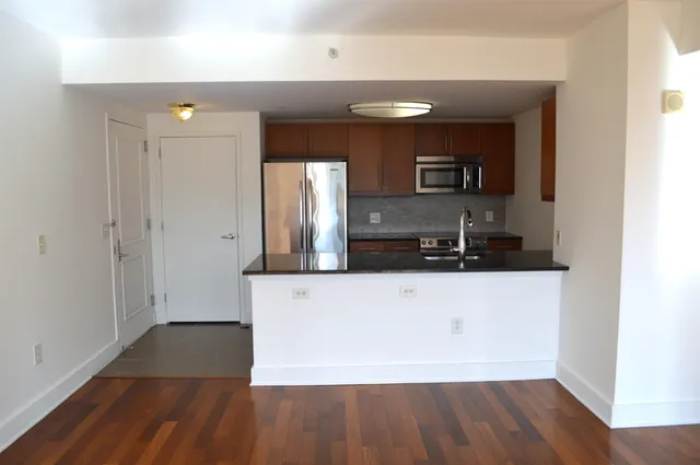 a living room with wooden floor and large mirror