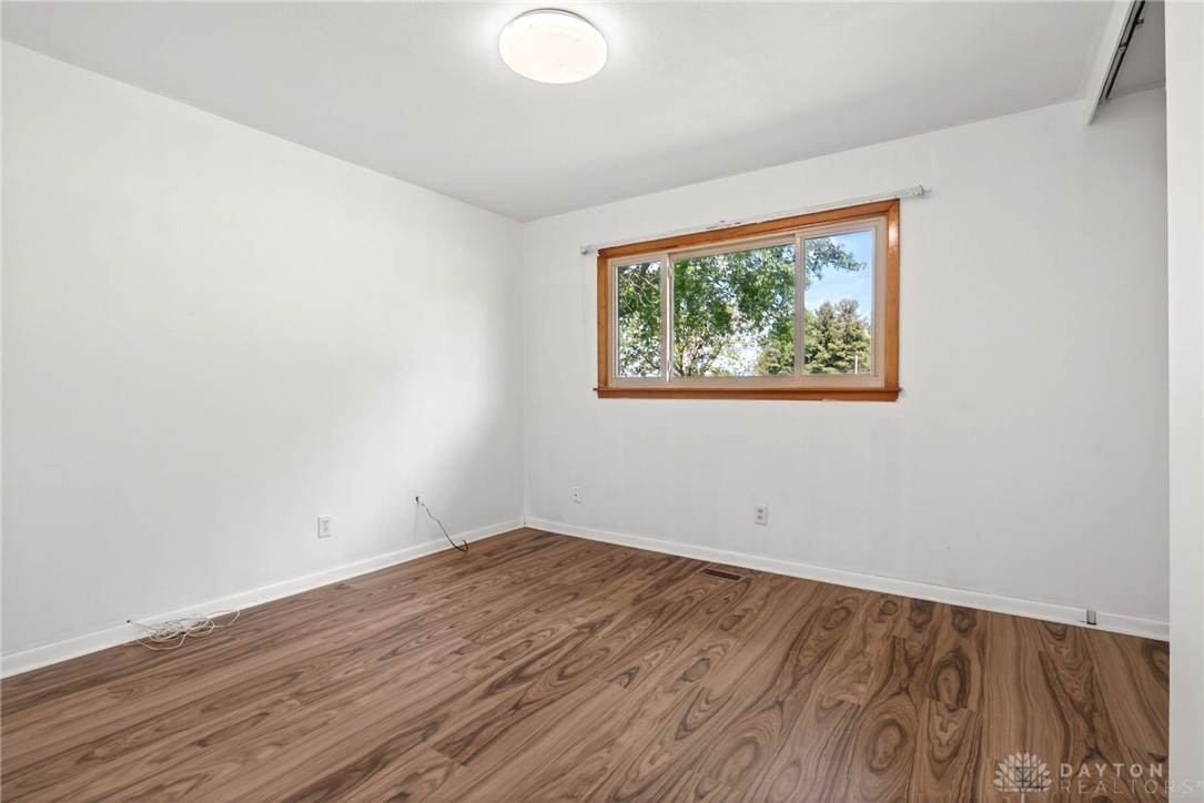 1005 Free Road New Carlisle, OH 45344 - Photo 25 of 43 Bright and airy room with large window and wood-look flooring awaits your personal touch.