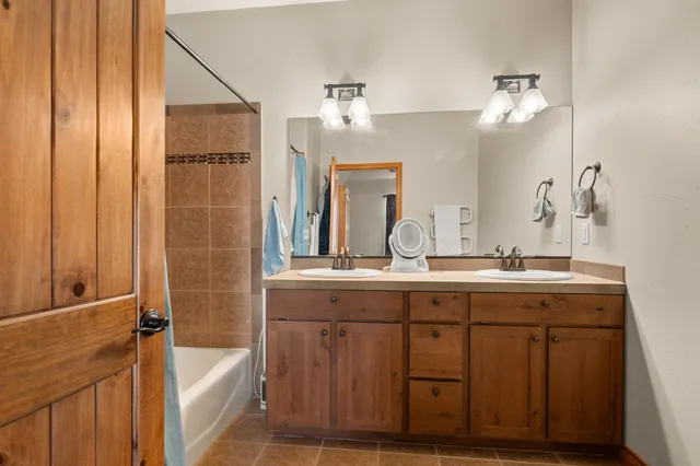 a spacious bathroom with a tub sink and mirror