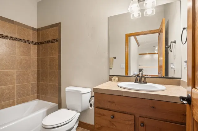 a bathroom with a sink a toilet a mirror and shower