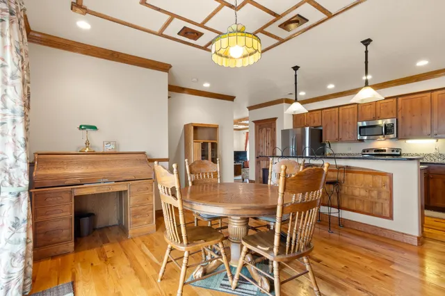 a kitchen with stainless steel appliances granite countertop a table chairs and a chandelier