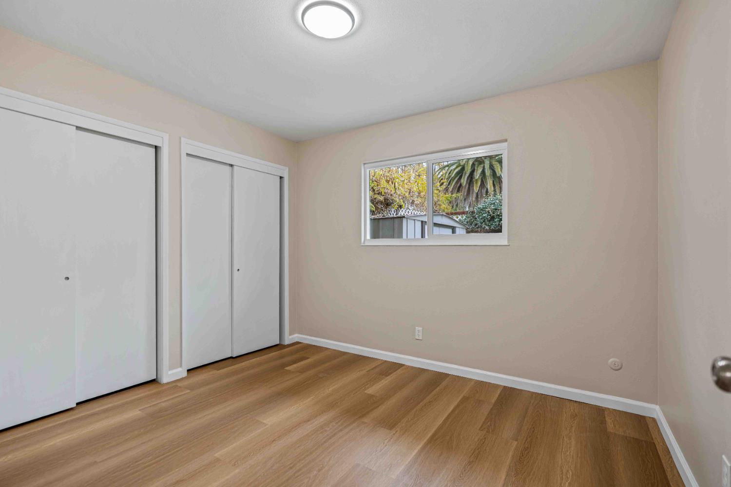 805 Tully Road, Unit 5 Modesto, CA 95350 - Photo 11 of 25 a view of an empty room with wooden floor and a window